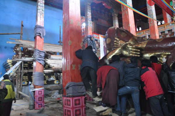 The local community helps erecting the statue of Buddha Shakyamuni.