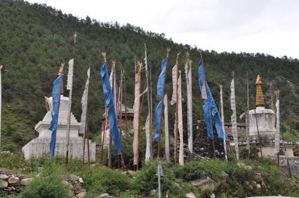 Stupas and prayer flags near a monastery